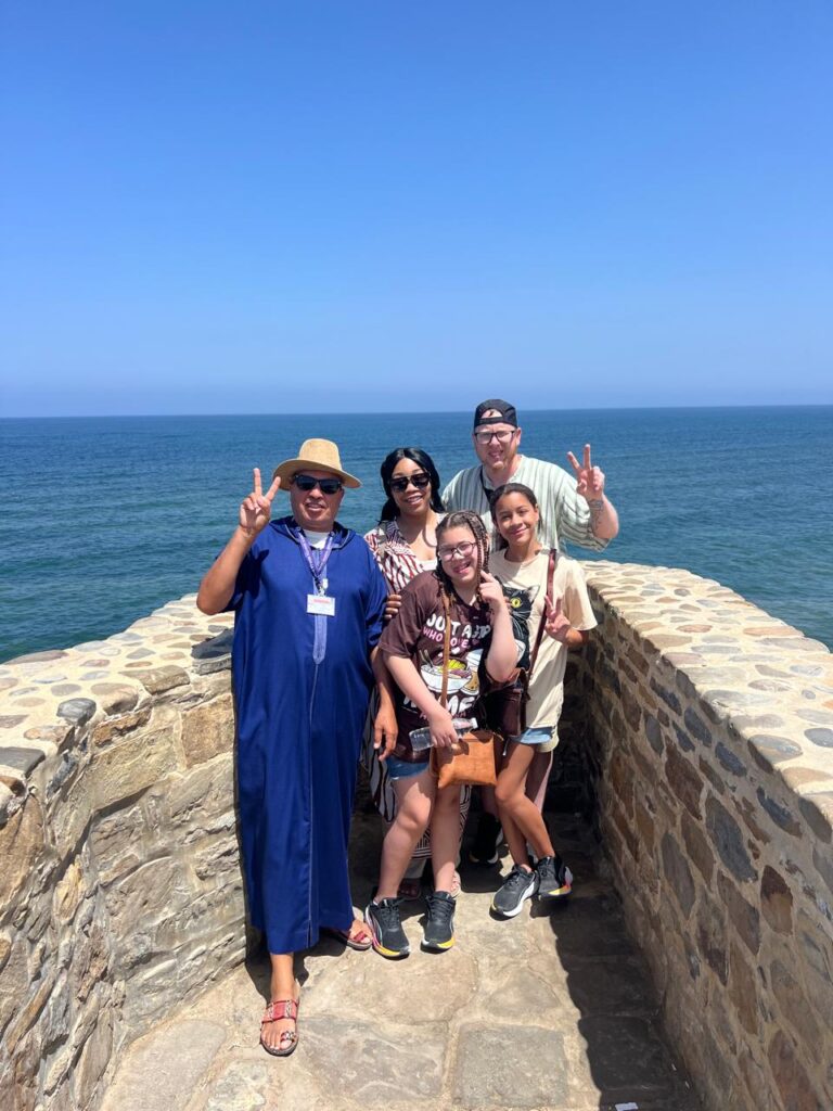 Family and guide on the sea bastion in Assilah