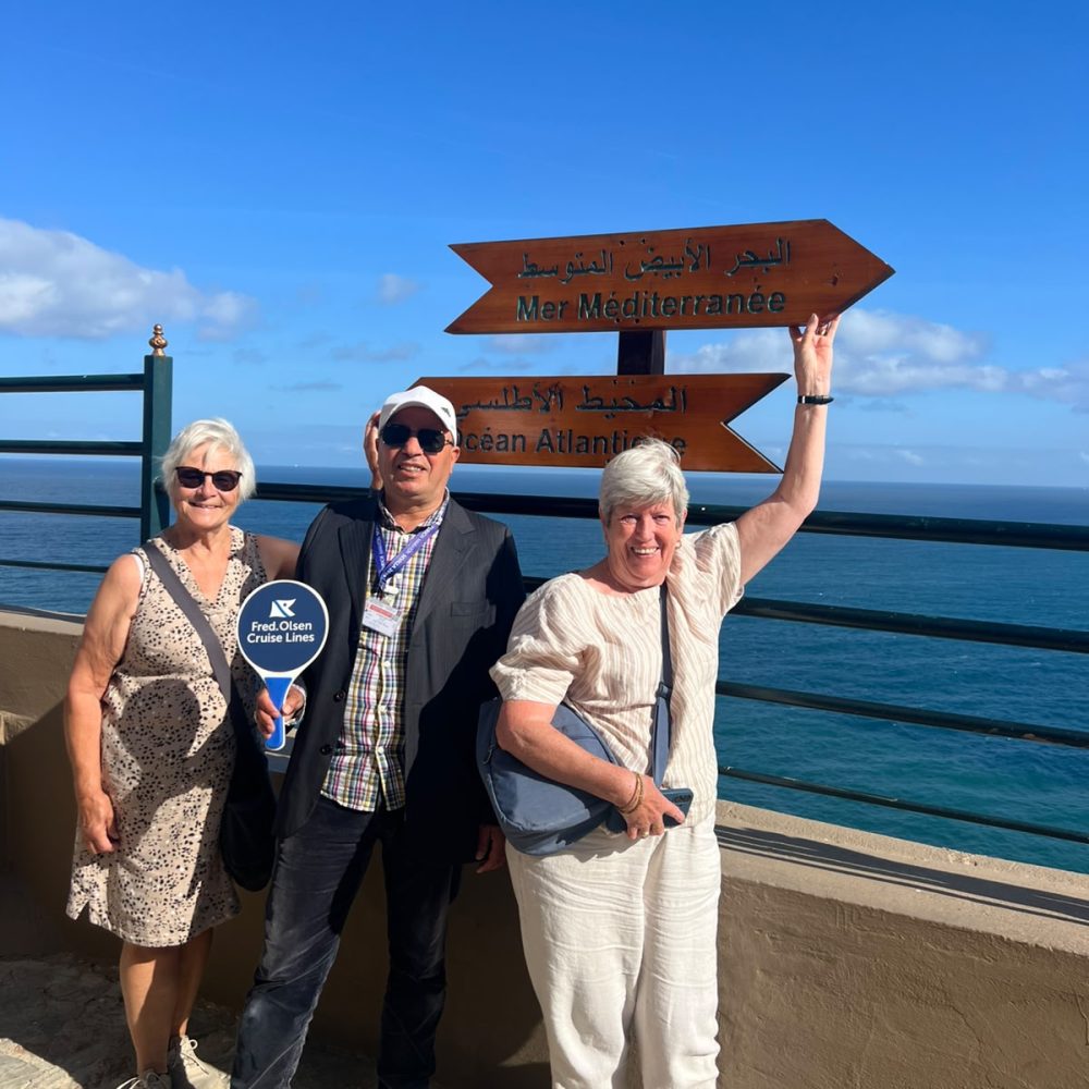 Touristes et un guide local privé au panneau du Cap Spartel où la Méditerranée et l'Atlantique se rencontrent.
